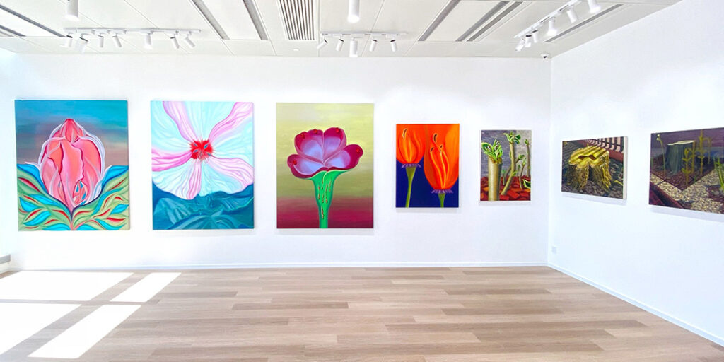 Colourful artworks of flowers on a white wall.