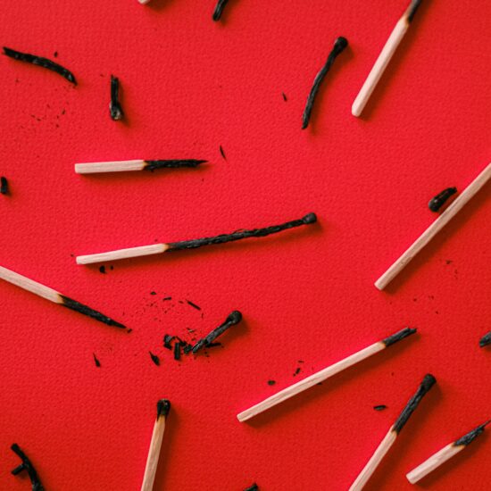 Burnt matches scattered on a red background.