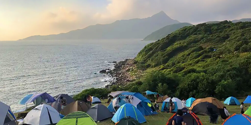 View over a campsite overlooking the sea and mountains of Tap Mun.