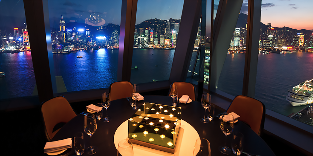 Formal restaurant table setting with a view of Hong Kong.