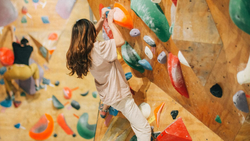 A woman scales an indoor rock climbing wall at Project_