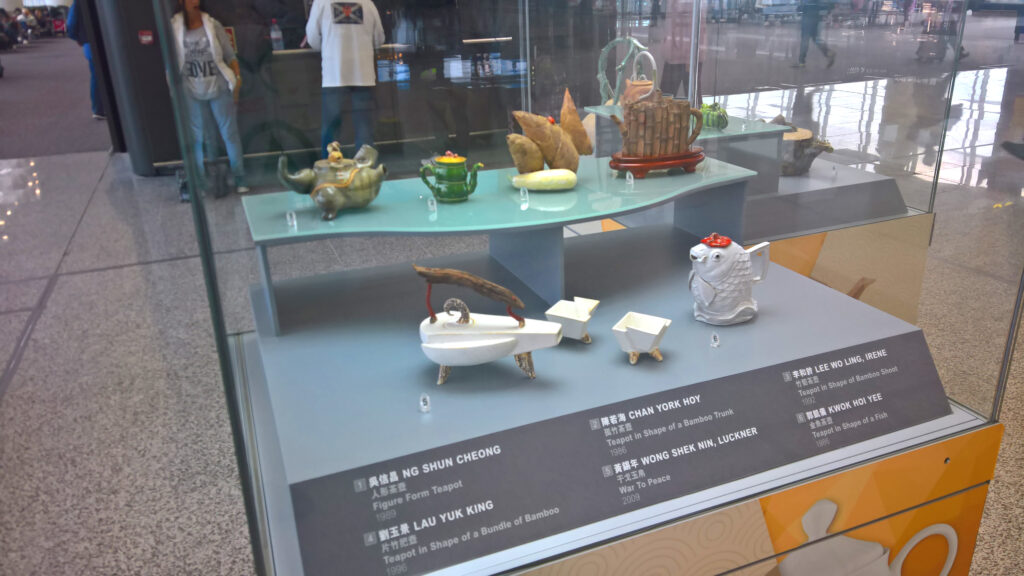 A glass showcase of different tea vessels and pots