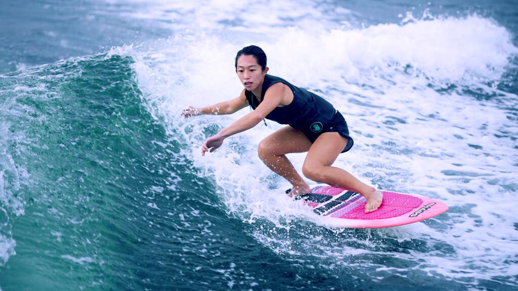 Woman wakesurfing on pink wakesurfboard