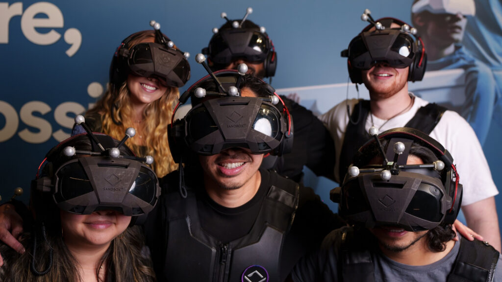 A group of friends wearing VR gaming headsets, getting ready to play at Sandbox.