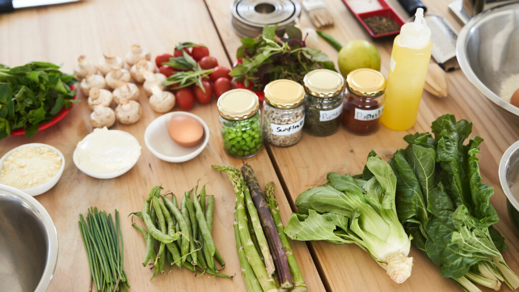 An assortment of fresh ingredients laid out on a wooden table ready for cooking.